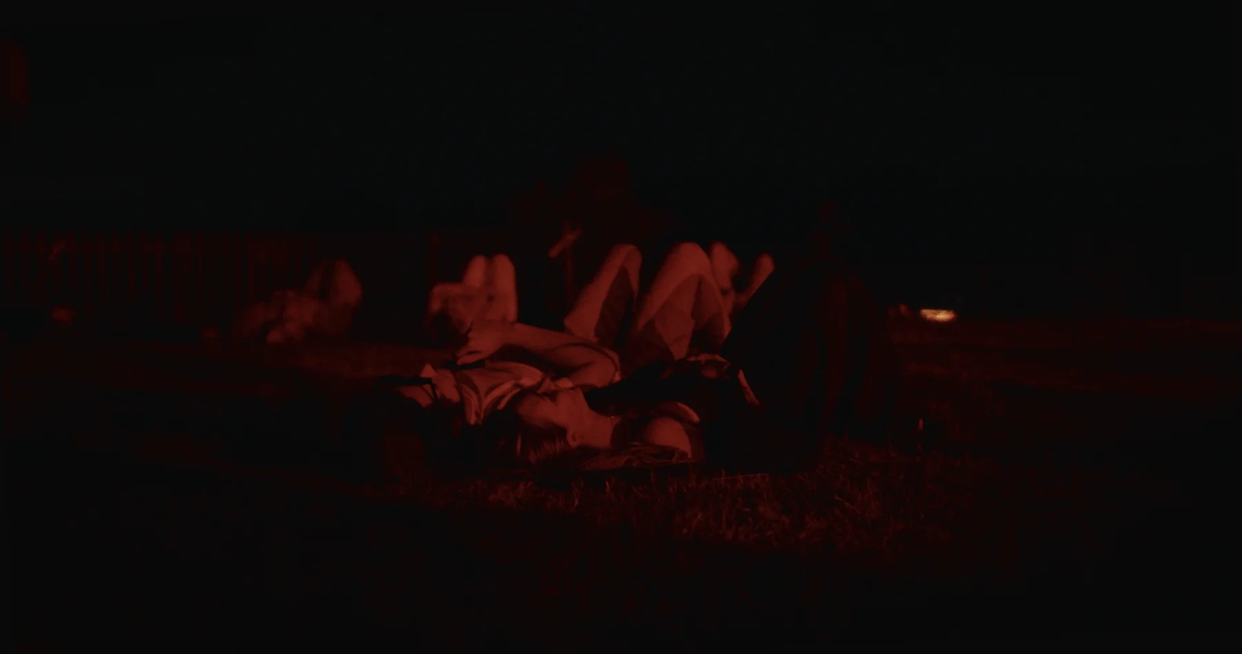 People lying together under deep red light at night