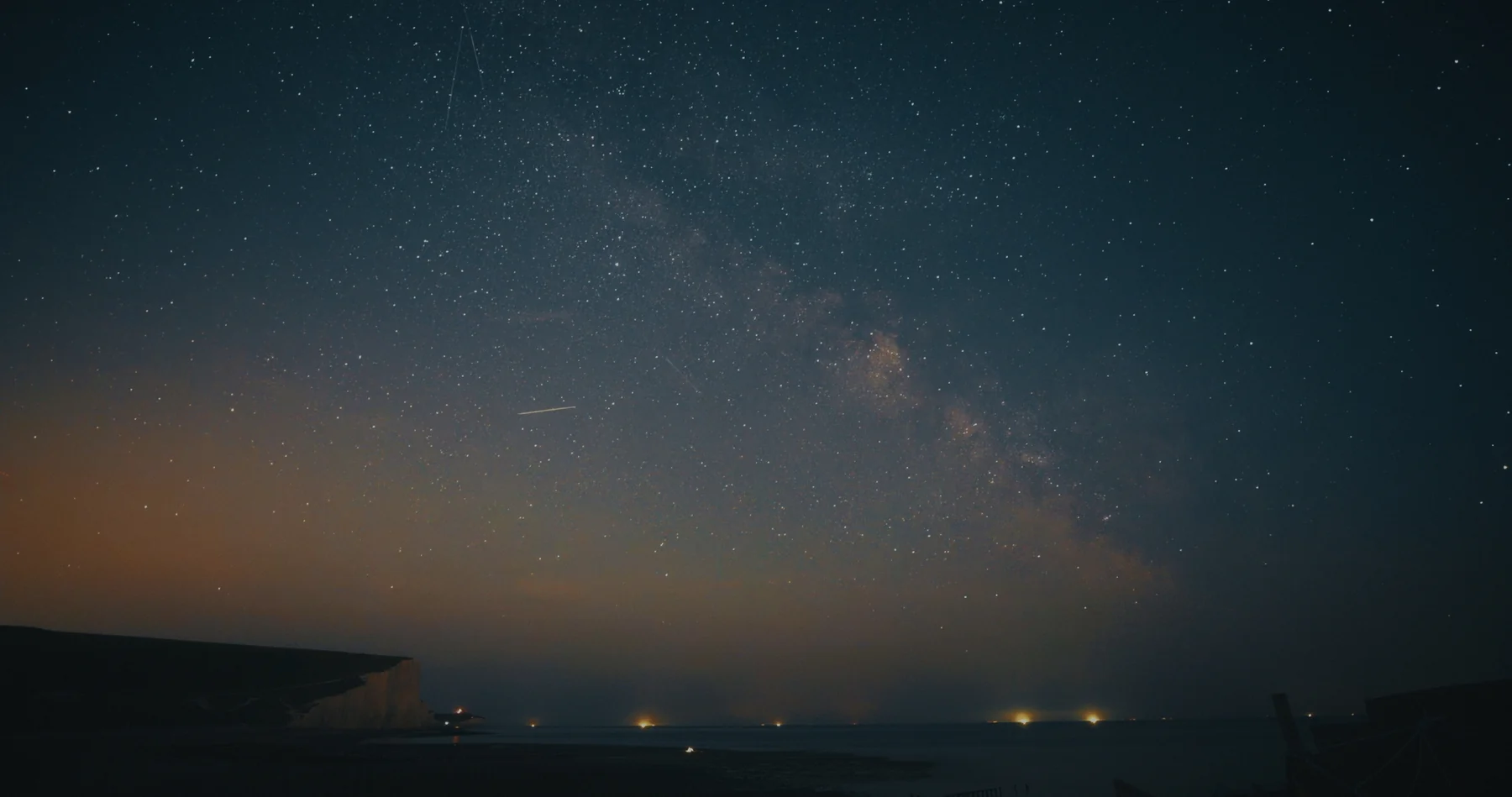 The Milky Way above a dark coastal horizon